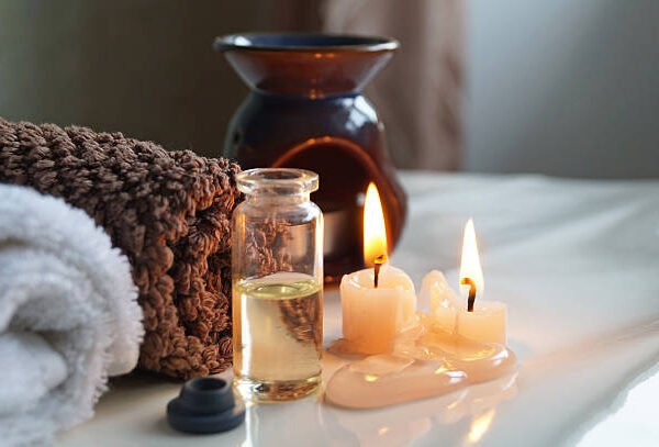 Spa set with fragrance oil in the bottle, towels and aromatic candles